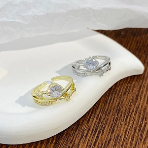 Cosmic orbit open ring with cubic zirconia in gold and silver set on a tray