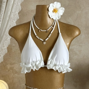 Close-up of white halter bikini top featuring delicate double-layer ruffle details