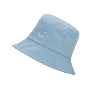 Close-up of light blue cotton bucket hat featuring a white embroidered smiley face design