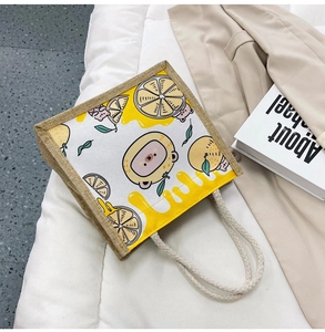 Detail of canvas tote bag with cartoon bear and lemon print with braided cotton rope handles