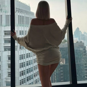 Détail d'une mini robe beige à épaules dénudées avec fronces latérales et manches longues