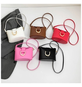 Flat lay of vintage bucket bags in five colors with metallic horseshoe hardware detail