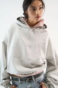 Detail of light grey leopard lined hoodie showing distressed ripped texture and vintage wash
