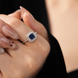 Detail of square-cut sapphire ring with zircon halo setting on silver band