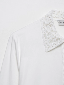 Gros plan sur le col délicat en dentelle au crochet blanc et la texture du chemisier