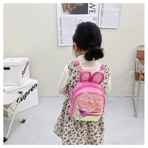 Detail of pink toddler backpack featuring bunny ears, mesh bow and iridescent front pocket