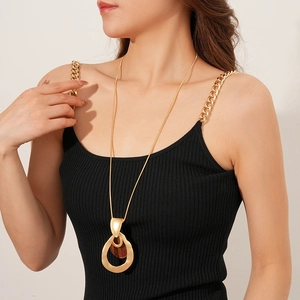 Detailed view of bohemian teardrop wood pendant necklace on model with golden chain