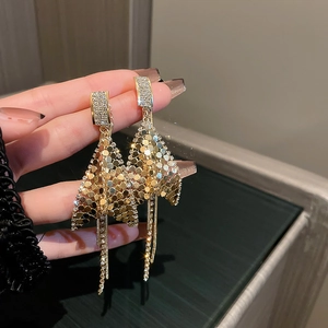 Macro view of gold tassel earrings featuring sparkling sequins and diamond fringes