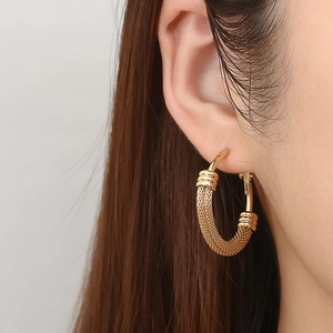 Boucles d'oreilles créoles chic en acier doré 18 carats style maille sur mannequin