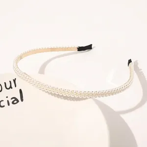 Close-up of elegant double-row pearl headband with gold metal base and black comfort tips