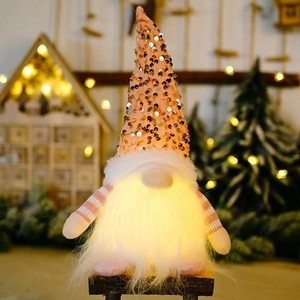 Pink sequin Christmas gnome with warm LED light and festive holiday background décor