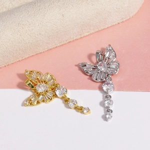 Detailed view of gold and silver butterfly pendants with sparkling cubic zirconia tassels