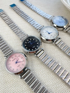 Close-up of quartet stylish women's quartz watches with rhinestone markers and steel bands