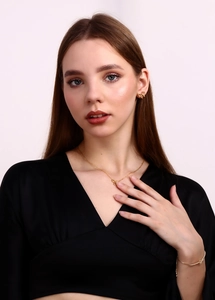 Detailed view of model wearing a 18K gold-plated bow-shaped necklace and earring jewelry set