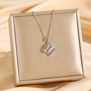 Collier en acier titane avec pendentif géométrique en zircon sur une boîte à bijoux