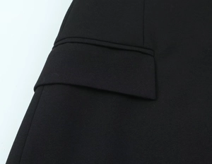 Dettaglio della patta della tasca strutturata sul vestito nero con spalline di qualità