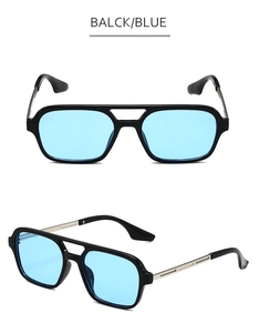 Detail of pilot sunglasses with black frame, blue translucent lenses and silver metal temples