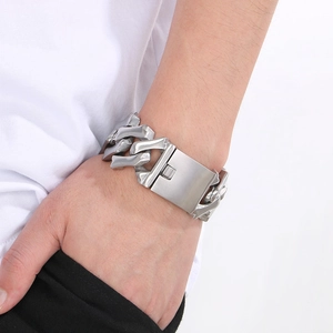 Gros plan d'un bracelet à gros maillons cubains argentés de 32 mm porté sur un poignet