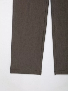 Détail des coutures de qualité et de la texture du tissu marron foncé du pantalon