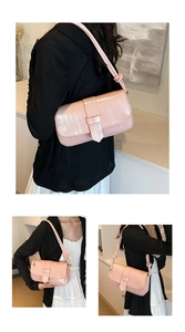 Detailed close-up of pink glossy shoulder bag featuring unique knotted strap design