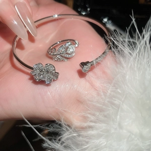 Dettaglio del set bracciale a fiore e anello a piuma in zircone argento con piume soffici