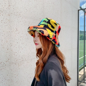 Detail view of colorful faux fur bucket hat with plush texture and vibrant patchwork pattern