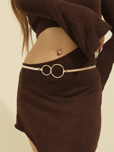 Close-up of golden metal spring waist belt featuring interlocking double ring buckle