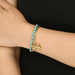 Detail of double-layer turquoise beaded bracelet with gold link chain and bow charm