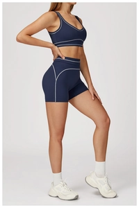 Detail of dark blue high-waisted yoga shorts with white contrast stitching and v-neck top