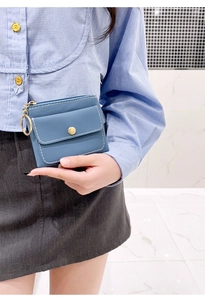 Close-up of blue leather coin purse with white stitching and gold snap closure