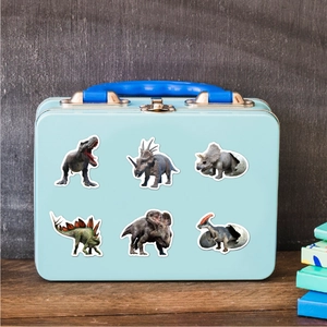 Detailansicht bunter realistischer Dinosaurier-Aufkleber auf einer blauen Metallbox