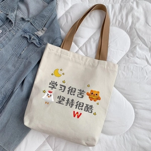 Detail view of durable off-white canvas tote bag with cute cartoon prints and brown handles