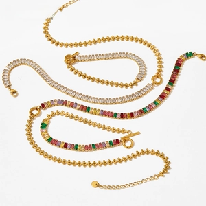 Flat lay of gold plated stainless steel necklaces and bracelets with colorful zircon stones