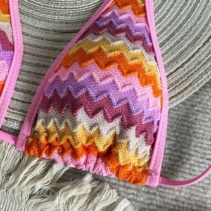 Macro shot of colorful zigzag crochet knit bikini top with vibrant stripe texture