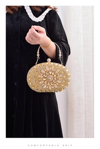 Detail of luxury gold oval clutch bag with diamond-encrusted surface and comfortable grip