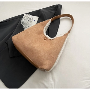 Detail view of khaki suede tote bag with white faux fur trim and brown leather shoulder strap