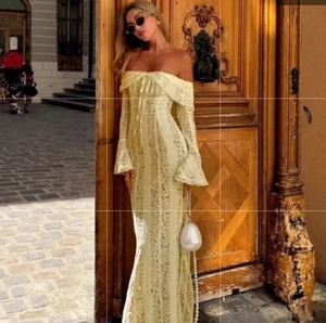 Detail of off-shoulder lace dress with elegant bell sleeves and bow tie neckline