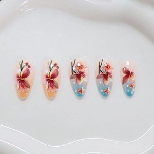 Faux ongles amande avec motif floral et dégradé de couleur bleu et rose doux