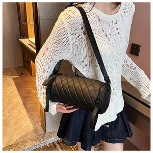 Schwarze gesteppte Nylon-Zylindertasche am Modell gezeigt für Größen- und Stilreferenz