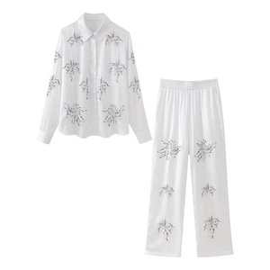 Women's two-piece white lounge set with beaded floral embroidery and silk texture
