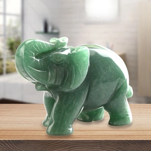 Detail view of a hand-carved green jade elephant statue with natural stone texture on wood