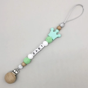 Detail of wooden and silicone pacifier clip with crown teether and BABY letter beads