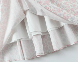 Dettaglio del vestito estivo a fiori viola chiaro con fodera bianca e tessuto leggero