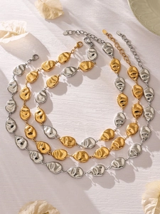 Flat lay of geometric gold and silver plated necklaces with textured abstract pendants