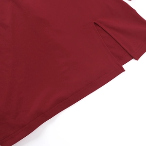 Détail de la fente latérale sur une robe en maille rouge foncé avec couture fine
