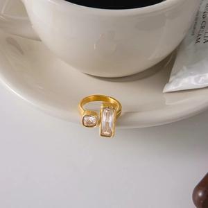 Detailaufnahme eines verstellbaren vergoldeten Rings mit klaren geometrischen Zirkonia