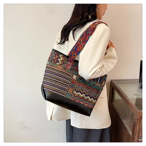 Detailed shot of ethnic tote bag with colorful geometric wave patterns and PU leather base