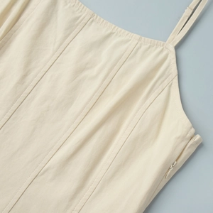 Detail of high-waist beige cotton dress with corset stitching and side invisible zipper