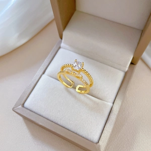 Golden double-layered bow ring with square-cut diamond and adjustable band in jewelry box