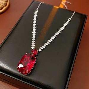 Detail of red square crystal pendant with silver rhinestone chain on black display